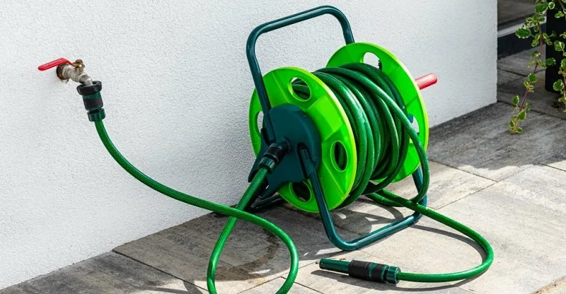 Scrubbing tent carpet with brush and rinsing with garden hose outdoors