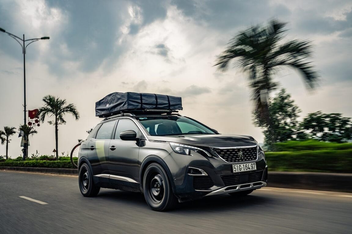 SUV with a rooftop tent prepared for a vehicle fuel-economy comparison.